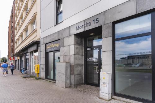 a store front with glass windows on a street at Apartamenty Przystanek Morska in Gdynia