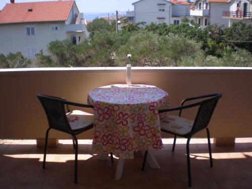 a table and chairs with a candle on a balcony at Guesthouse Goga in Rab