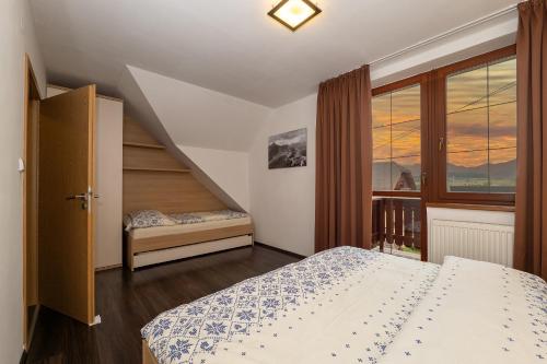 a small bedroom with a bed and a staircase at Apartmán SkyNest Tatry - Veľká Lomnica in Veľká Lomnica