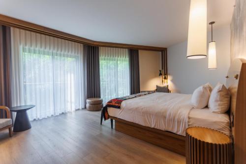a bedroom with a large bed and a large window at Hôtel-Musée Premières Nations in Wendake