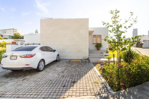 a white car parked in front of a house at Casa Moderna en Cumbres del Lago Juriquilla in Juriquilla
