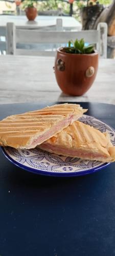 a sandwich on a blue and white plate on a table at Pousada Cavallitos d'Amar in Ilha de Boipeba
