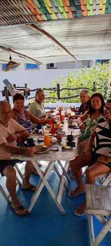 a group of people sitting at a picnic table at Pousada Cavallitos d'Amar in Ilha de Boipeba