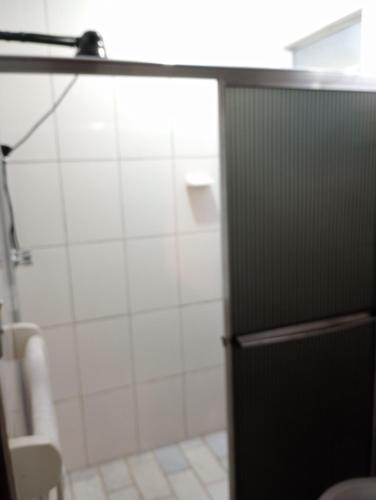 a bathroom with a shower and a black door at Pousada Arboretum in Penedo