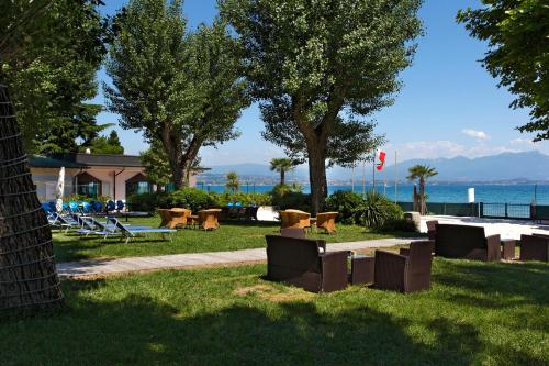 a park with benches and a view of the water at Residence Spiaggia D'Oro in Desenzano del Garda