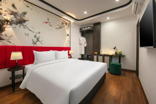 a bedroom with a white bed and a red headboard at Hanoi Grandeur Hotel & Spa in Hanoi