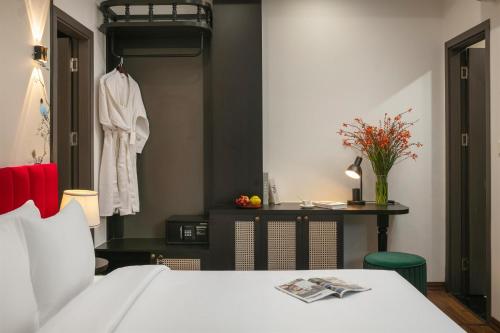 a bedroom with a bed and a table with a dresser at Hanoi Grandeur Hotel & Spa in Hanoi