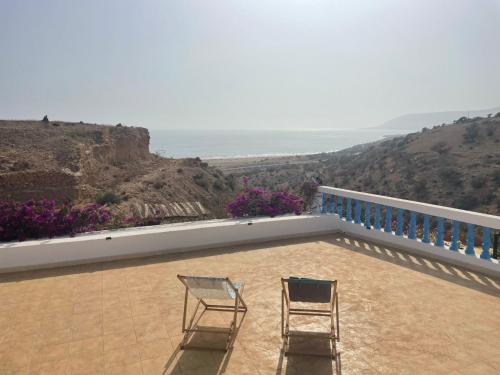 two chairs sitting on the balcony of a house at Auberge Villa des Jasmins in Aghroude