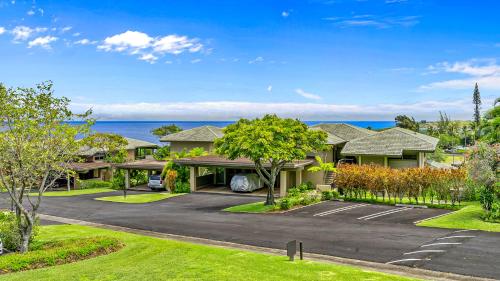 a house with a parking lot in front of the ocean at Kapalua Ridge Villa 1721 in Kapalua