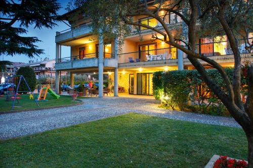 a house with a playground in front of it at Residence Spiaggia D'Oro in Desenzano del Garda