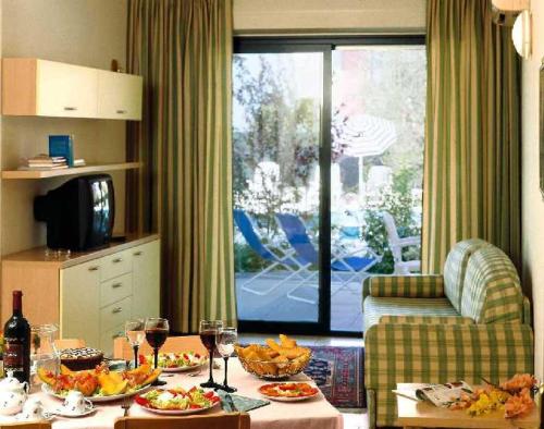 a living room with a table with food and wine glasses at Residence Spiaggia D'Oro in Desenzano del Garda