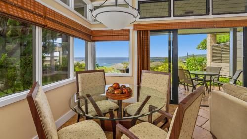 a dining room with a table and chairs and windows at Kapalua Ridge Villa 1511 in Kapalua