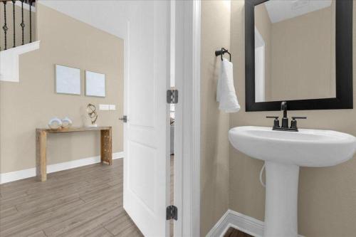 a bathroom with a sink and a mirror at Luxury e Themed Rooms Minutes from Disney Parks in Kissimmee