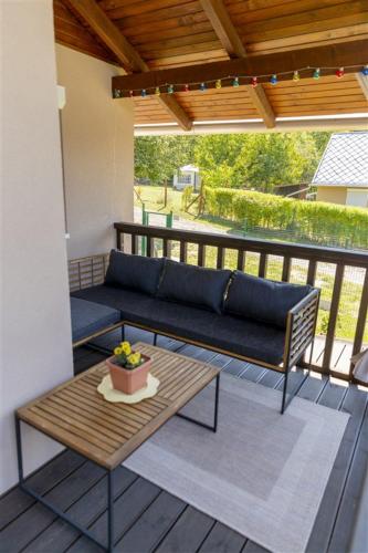 a patio with a couch and a table on a deck at Tornácos Vendégház in Salgótarján