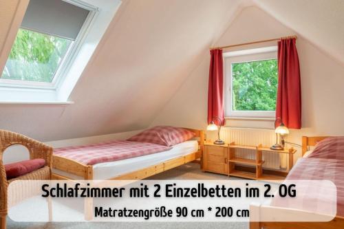 a attic bedroom with two beds and two windows at Bauernhof Wisch-Hof - 3 km zum Ostseestrand, 20 km nach Kiel - viele Ausflugsziele in der näheren Umgebung, ideal zum Fahrradfahren in Krokau