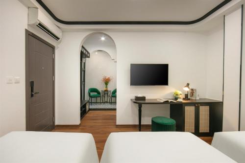 a room with a desk and a tv on a wall at Hanoi Grandeur Hotel & Spa in Hanoi