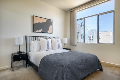 een slaapkamer met een bed en een groot raam bij Palo Alto 2br w pool parking nr dining SFO-1418 in Palo Alto