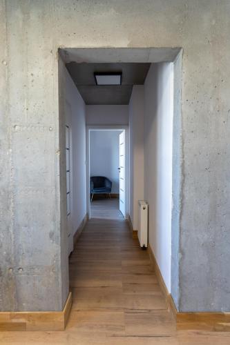 an empty hallway in a room with white walls and wood floors at Apartamenty Przystanek Morska in Gdynia