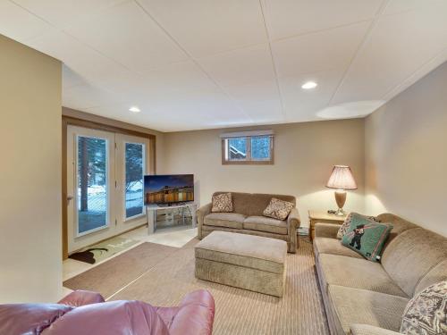 a living room with two couches and a tv at 679 Disciples Village Unit in Boyne Falls