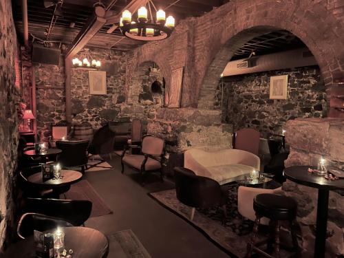 a bar with tables and chairs in a room with stone walls at Swedetown European Style Hostel by Heirloom Boutique Collection in Duluth