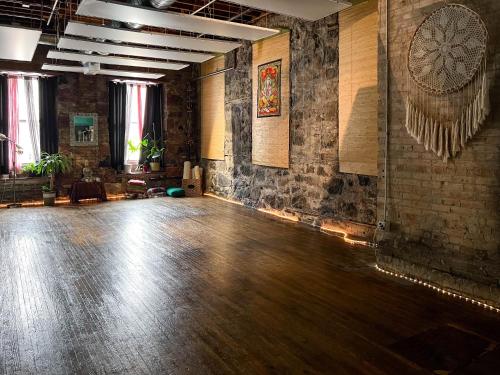 a room with a wooden floor and a brick wall at Swedetown European Style Hostel by Heirloom Boutique Collection in Duluth