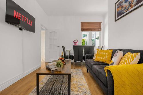 a living room with a couch and a table at Bright and Cosy 3-bedroom Home near Manchester - Free parking - Sleeps 6 in Manchester
