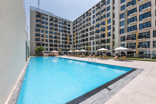 a large swimming pool in front of a building at Waves - Stylish Blue Haven near Town Square Park in Dubai