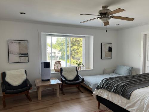 a bedroom with a bed and two chairs and a tv at Luxury New 5-bedroom 4- bathroom Single House in Surrey