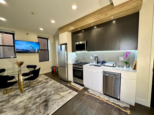 a kitchen with a sink and a table with chairs at BP STAYS - Hotel-Style, No Host, Professionally Managed ID286 in Jersey City