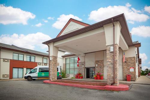 a building with a car parked in front of it at Quality Inn & Suites 5585 Ambler Drive Mississauga Ontario in Mississauga