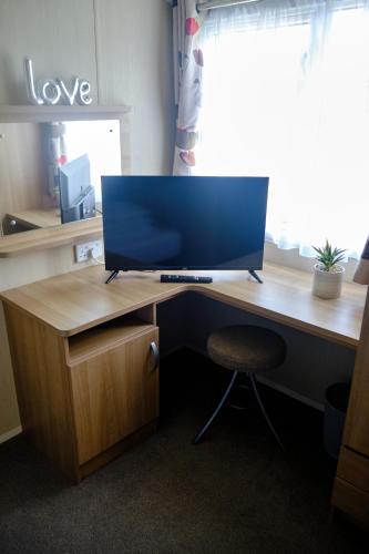 a desk with a computer monitor on top of it at 64 Southfield - Skipsea Sands in Ulrome