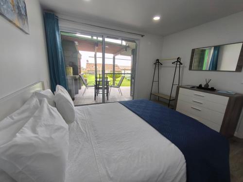 a bedroom with a white bed and a balcony at Flor da Natureza - Flor in Pilar