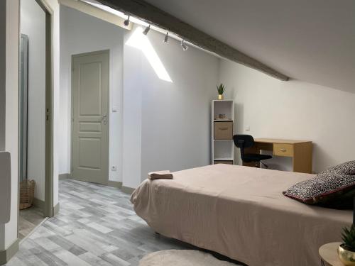a bedroom with a bed and a desk and a door at Chambres centre ville Chateauneuf in Châteauneuf-sur-Charente