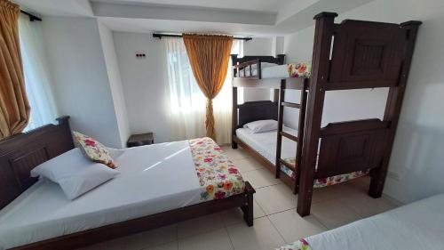a bedroom with two beds and a bunk bed at Hotel La Santamaria - Montenegro Quindío in Montenegro