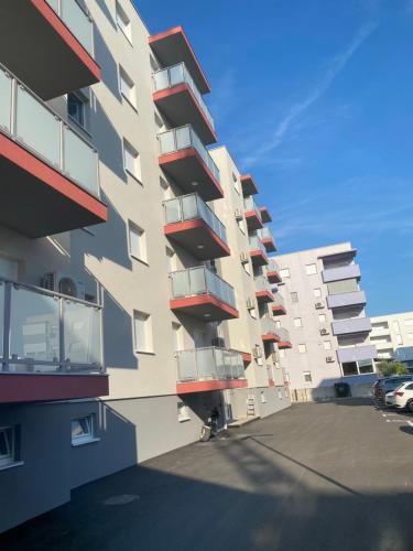 a tall building with balconies on the side of it at Apartman Katamar in Ljubuški