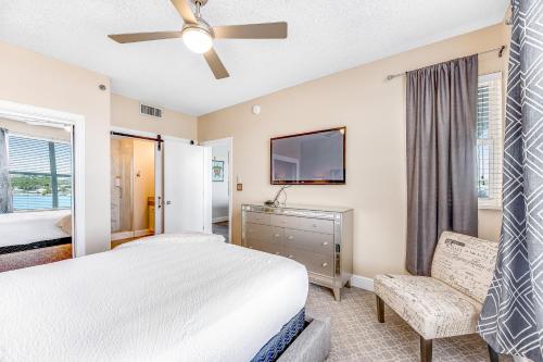 a bedroom with a bed and a flat screen tv at Palm Court Yacht Club #303 in Fort Walton Beach