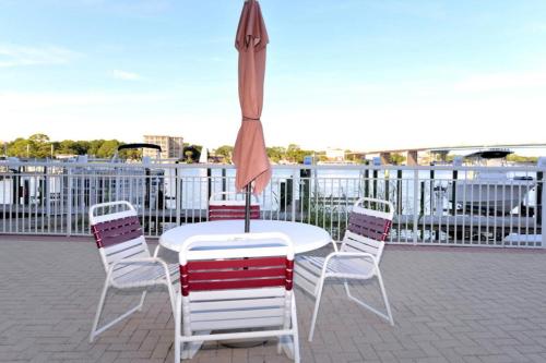 a table and chairs with an umbrella on a patio at Palm Court Yacht Club #303 in Fort Walton Beach