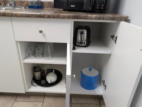 a kitchen cabinet with a microwave and a counter at Gordie's Inn & Suites in Alert Bay