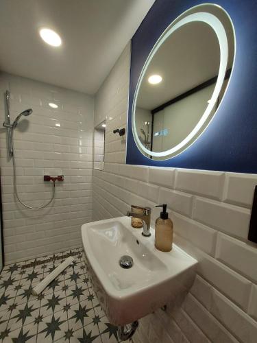 a bathroom with a sink and a mirror at Titi Boutique Apartmanok in Bükfürdő