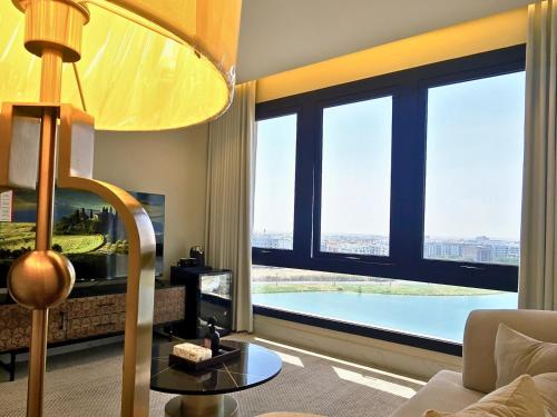 sala de estar con ventana grande con vistas a la piscina en Luxury suite with sea view, en Al Khobar