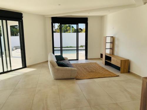 Una sala de estar con una silla y una mesa. en Villa Horizon, en Saint-Paul