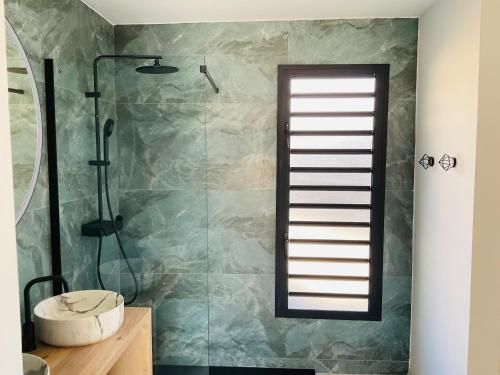 y baño con ducha, ventana y aseo. en Villa Horizon, en Saint-Paul