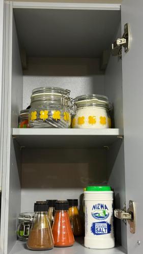 a shelf with jars and other items in a refrigerator at شقه للايجار يومي في منتجع السيفه in Muscat