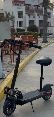 a scooter parked on a sidewalk next to benches at شقه للايجار يومي في منتجع السيفه in Muscat