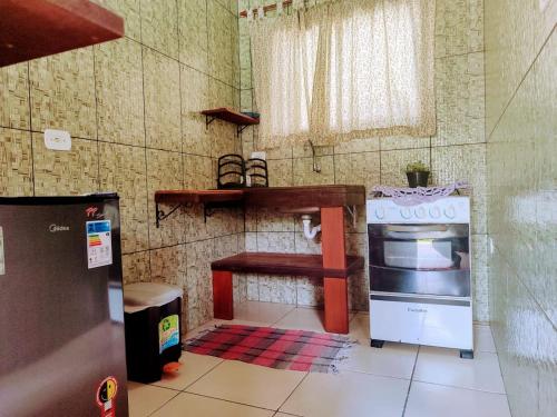 a small kitchen with a stove and a counter at Pousada Canto Verde in Paraty