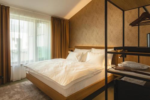 a bedroom with a large white bed and a window at Hotel Bronzo Brno in Brno