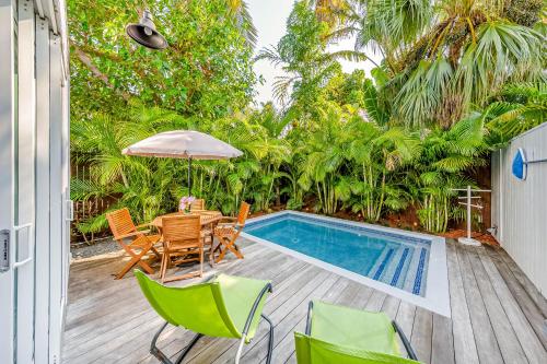 Un patio con mesa y sillas y una piscina. en Island Retreat, en Key West