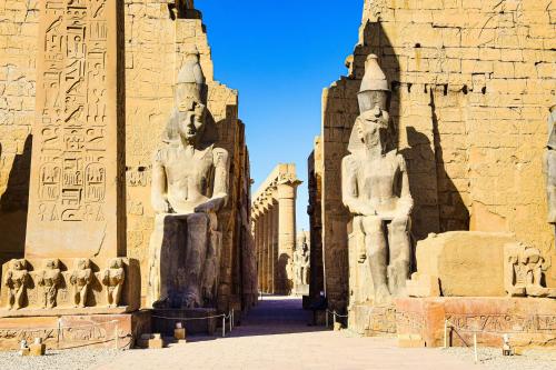a group of statues standing next to a building at White Gorf Hotel in Luxor