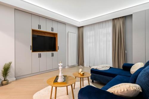 ein Wohnzimmer mit blauen Möbeln und einem Flachbild-TV in der Unterkunft Sia North Blue in Voluntari