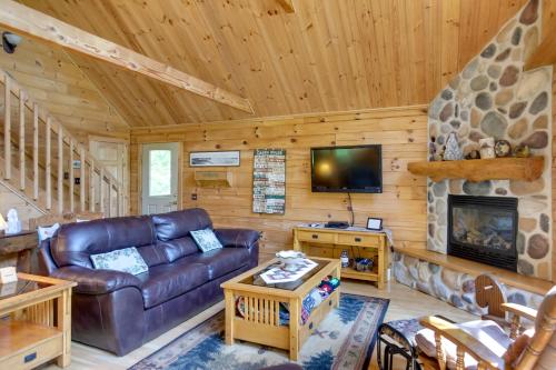 a living room with a couch and a fireplace at Lakefront Hazelhurst Cabin Dock and Pool Table in Hazelhurst